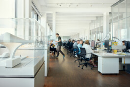 Großzügiges, modernes Büro in Düsseldorf mit Büros für professionelle Mitarbeiter. Ein Architekturmodell ist prominent am Eingang ausgestellt und verkörpert die Essenz des Unternehmensalltags. Große Fenster durchfluten den Raum mit natürlichem Licht und machen ihn ideal für Unternehmensfotografie. Portrait und Reportage Fotografie für Corporate und Editorial